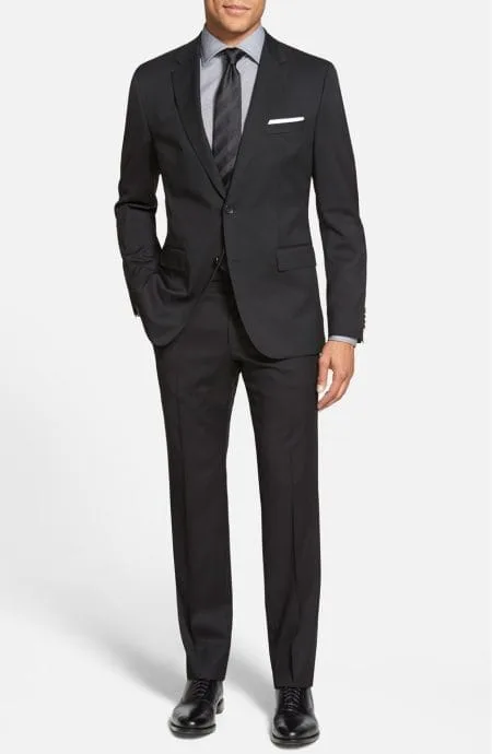 Front view of The Essential Black Suit for men, custom-tailored in fine worsted wool.