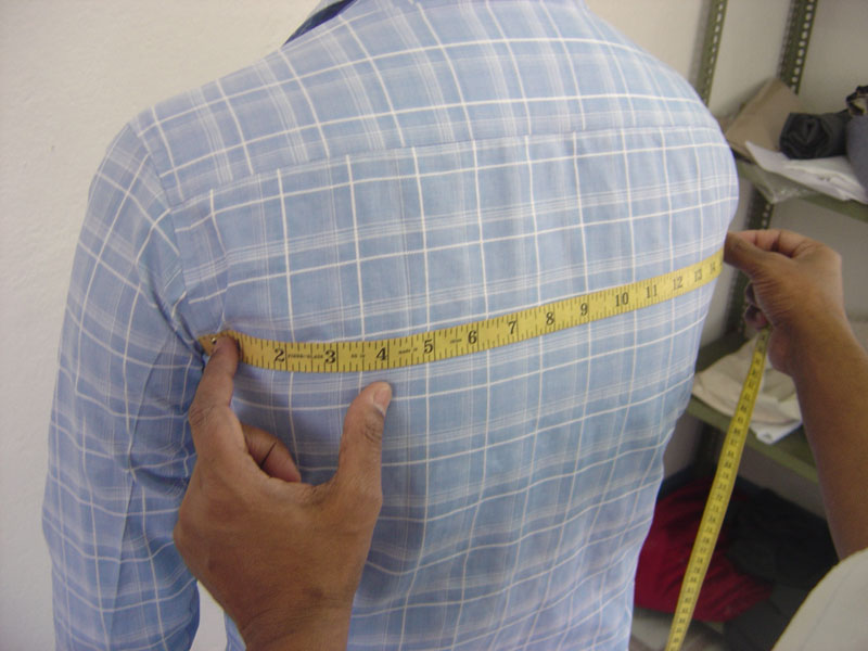 Measuring men's body back chest for the custom-made garments. A left view.