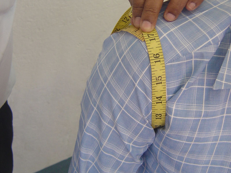 Measuring men's body armhole for the custom-made garments.