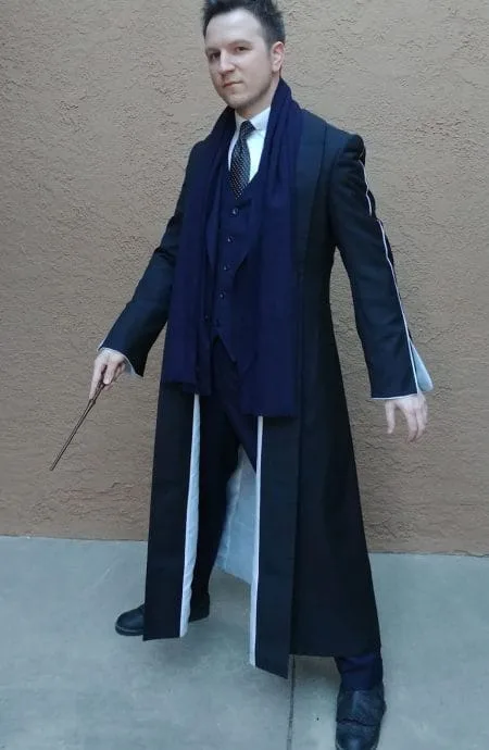 Fantastic Beasts Percival Graves black coat in a mean face posture with wand down.