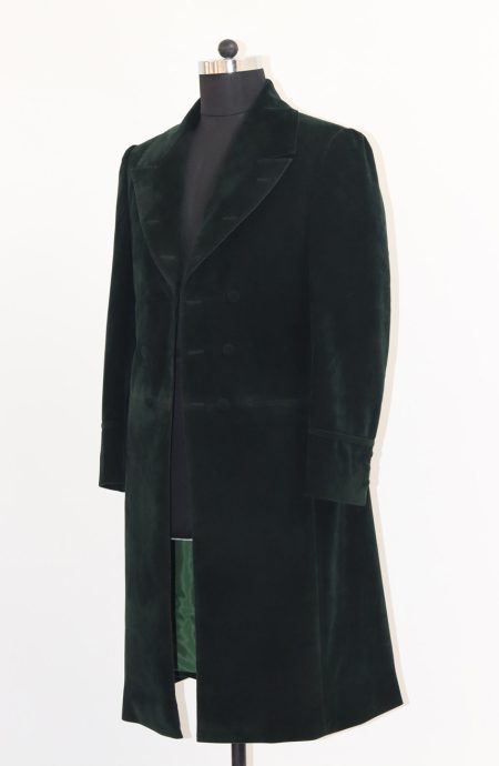 Full side view of the green velvet frock coat on a stand with the sleeve position, cuffs, and button details.