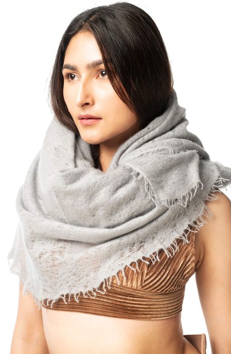 Gray cashmere scarf wrap worn loosely around the neck and shoulders