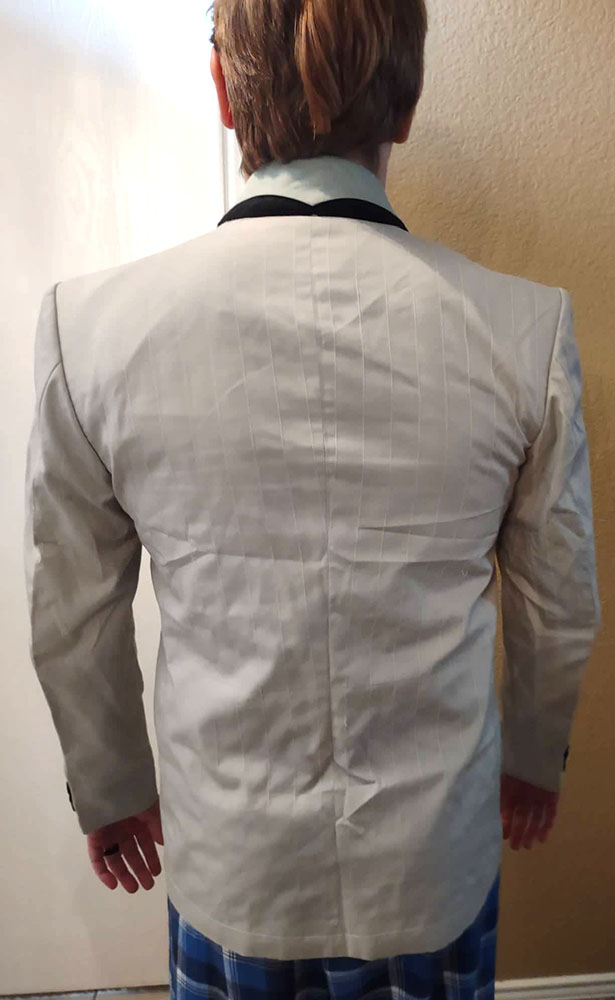 This is a back view of the Good Omens Season 02 Crowley black blazer test fitting on a customer. It displays tailored details with a structured shoulder design.