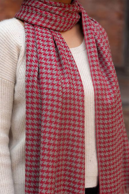 Close-up of red houndstooth cashmere scarf showing fine diamond weave texture and premium cashmere fibers.