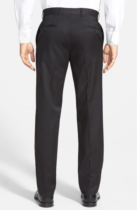 Back view of The Essential Black Wool Trousers, showcasing the clean lines and expert tailoring of the seat and the classic button-through welt pockets.