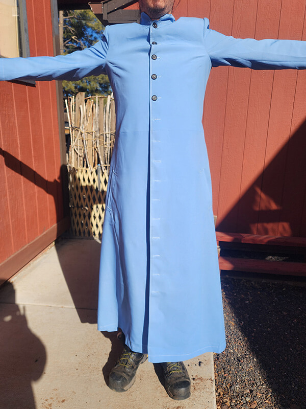 Full-length front view of the test coat with arms stretched out for the custom-made Neo Leather Trench Coat. This set of image demonstrates the overall fit and flow of the coat, including armhole height, neck fit, and the number of buttons. The test coat is used to verify sizing and style before the final black leather version is crafted.