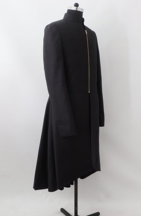 Side view of a men's black wool tailcoat with a high collar and asymmetrical gold zipper, showing the flared back.
