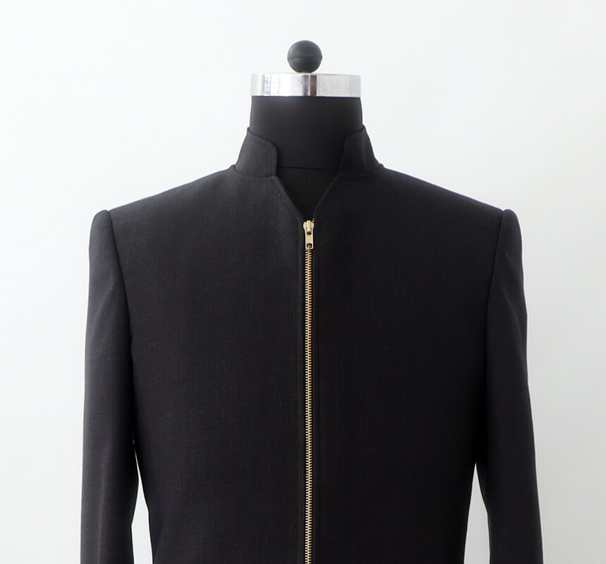 close-up of the high stand-up collar and gleaming gold asymmetrical zipper on the men's wool tailcoat.