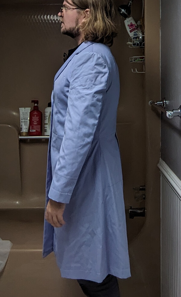 Side profile view of a customer in Baron Boutique’s Time Lord Test Frock Coat, highlighting sleeve length, coat silhouette, and fit adjustments before final tailoring.