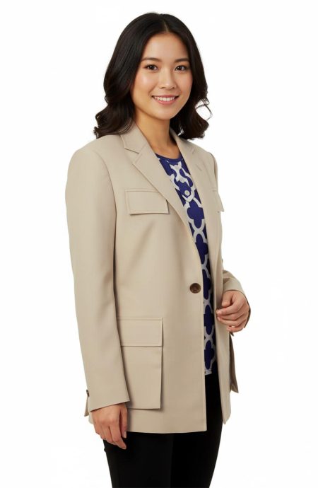 A smiling woman models the women's 7th Doctor utility jacket. The image shows the stone-colored wool gabardine jacket from the front, highlighting the notch lapels, chest pockets, and hip pockets.