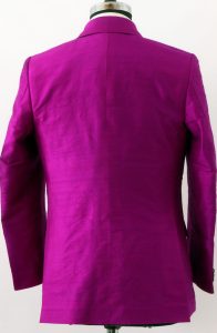 Back view of a magenta Dupioni silk suit jacket on a mannequin showing the double vents and sleeve drape.