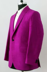 Angle view of a custom magenta Dupioni silk suit jacket with a shawl collar, displayed on a mannequin.