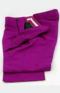 Detail shot of custom magenta Dupioni silk trousers, folded to show the waistband and flat-front construction.