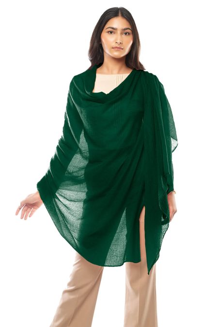 A woman models a forest green featherlight cashmere scarf over a light top and khaki pants. The scarf is draped elegantly around her, creating a stylish, flowing silhouette.