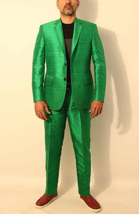 Front view of a man wearing a vibrant green custom-made 100% Dupioni silk suit with two button closure and flap pockets.