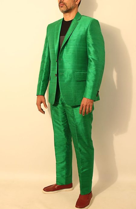 Man in a custom green Dupioni silk suit shown from an angled perspective to display the suit's texture and sheen.