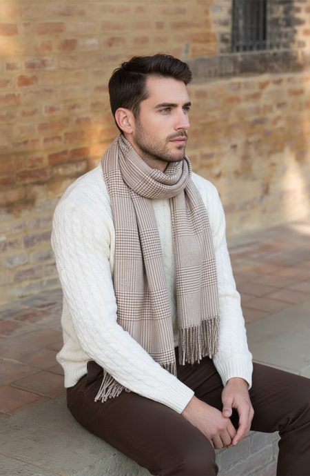 Man in cream knit sweater wearing a tan and white glen plaid cashmere scarf draped elegantly around the neck, showcasing sophisticated tailoring and premium houndstooth pattern.