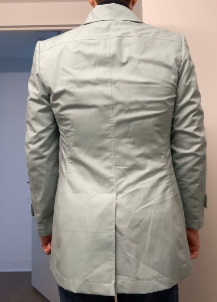 Back view of complimentary fitting toile for mens car coat showing bespoke tailoring process and center back vent construction.
