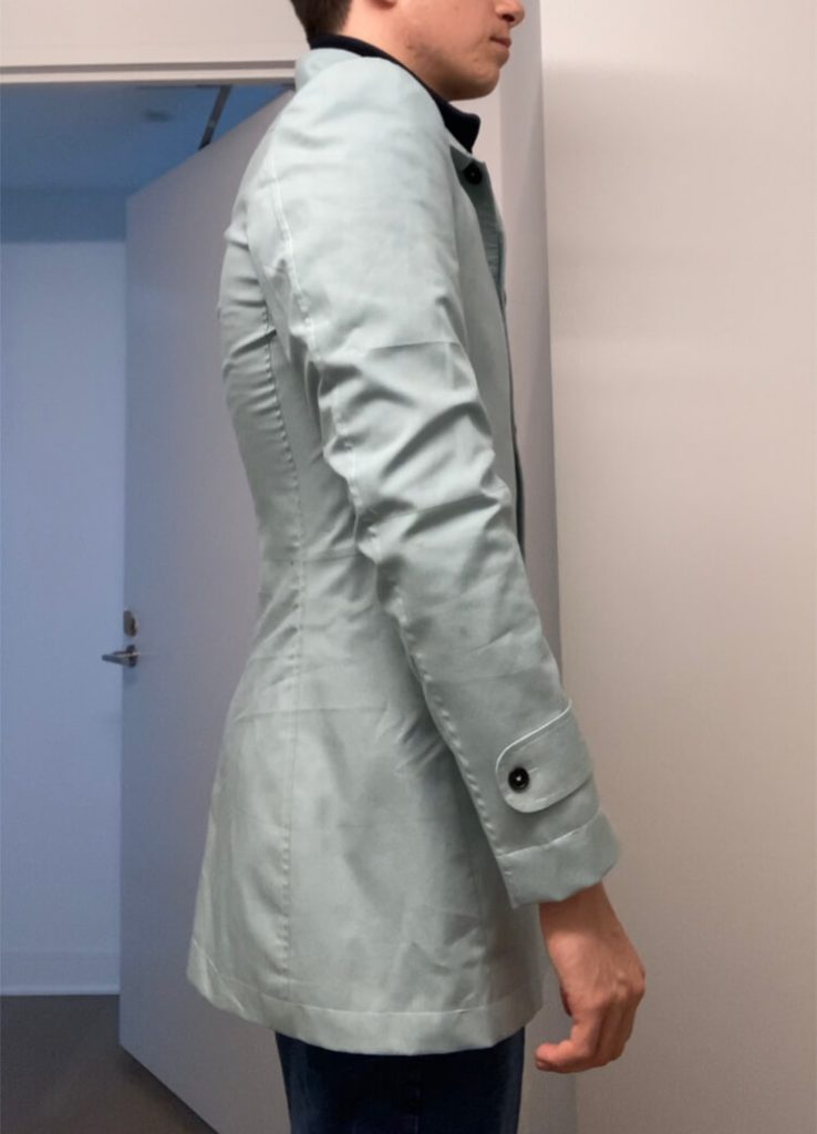 Right side view of car coat fitting toile showing hand-set armholes and sleeve construction in preliminary fitting garment.