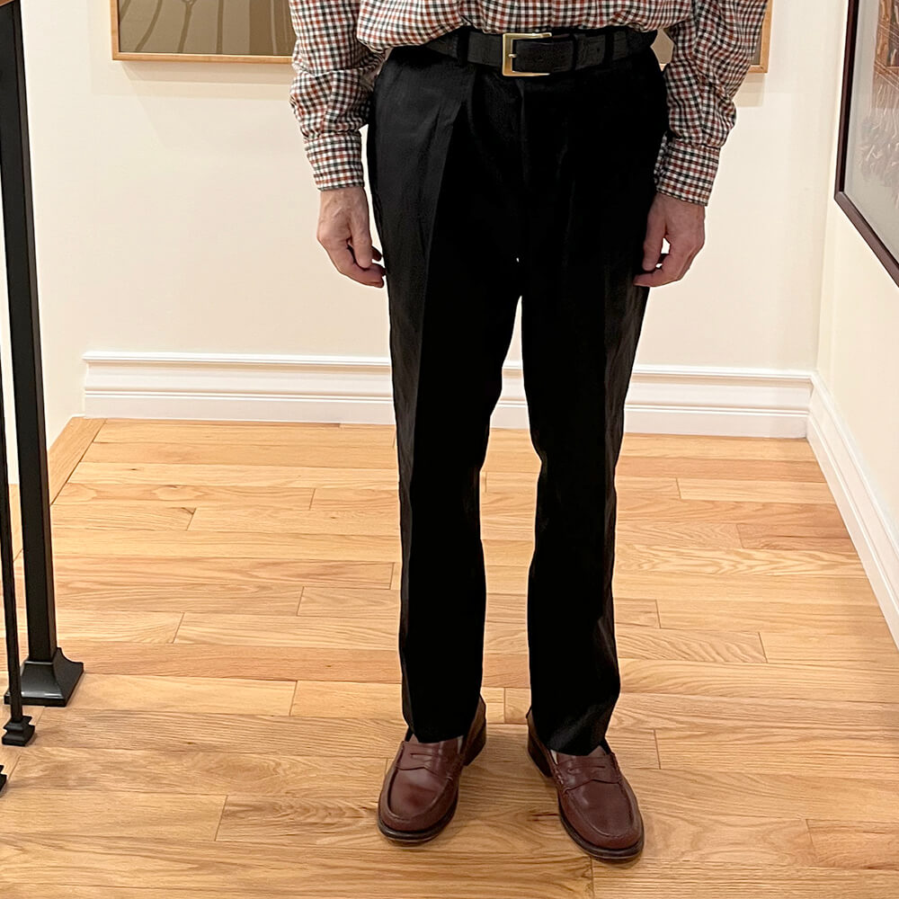 Front view of men's bespoke dupioni silk dress pants in black with flat-front design, zip fly closure, and side pockets.