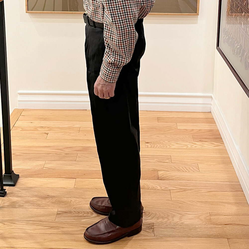 Side profile of custom-tailored men's dupioni silk trousers displaying clean straight leg line and proper hem break.