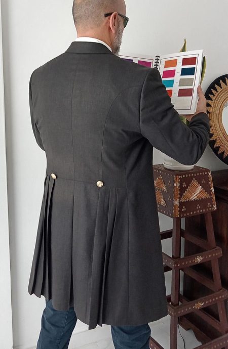 12th Doctor grey linen coat back view showing signature pleated skirt panels and decorative gold buttons. The series 10 Peter Capaldi cosplay replica, Baron Boutique.