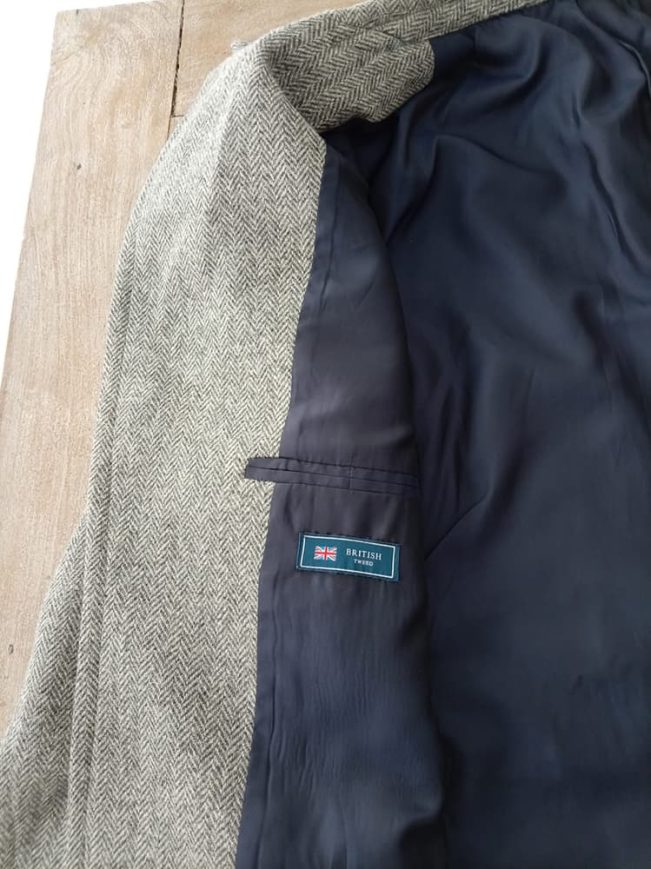 Newt Scamander inspired grey herringbone tweed coat cloth featuring premium lining, authentic British tweed fabric label, and refined handcrafted tailoring.