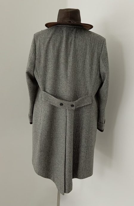 Back view of Fantastic inspired grey tweed coat featuring authentic herringbone texture, belted back detail, and timeless British tailoring for wizard-inspired fashion lovers.