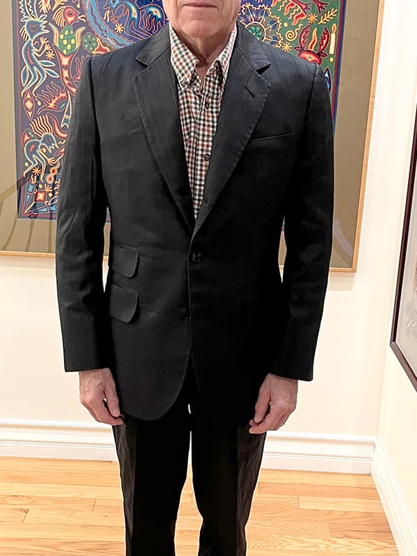 Happy customer wearing a custom-tailored black dupioni silk 3-roll-2 suit by Baron Boutique, featuring a soft rolling lapel, vertical grain, and elegant silk sheen.