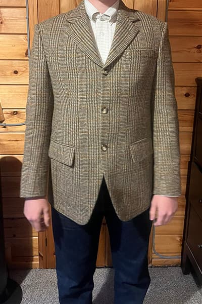 Happy customer wearing a bespoke Shetland tweed blazer tailored by Baron Boutique, front view showing the structured fit, natural drape, and aligned tweed pattern.