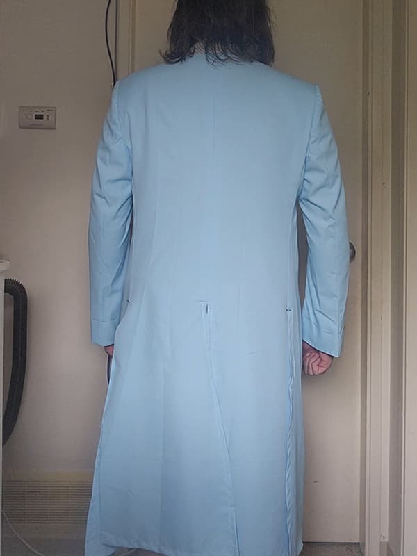Rear view of a Heath Ledger Joker–inspired purple test coat from The Dark Knight, shown on a male model. This tailoring mock-up is used for fit and measurement verification prior to final construction, highlighting the back seam structure and long tailored silhouette.