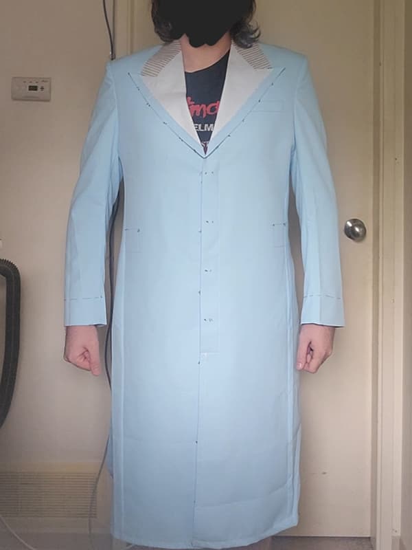 Front view of a Heath Ledger Joker–inspired purple test coat from The Dark Knight, displayed on a male model. This fitting garment is used to verify measurements and silhouette before crafting the final bespoke coat, featuring a structured longline cut and 5-button front closure.