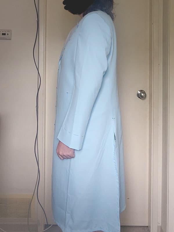 Left side view of a Heath Ledger Joker–inspired purple test coat fitting garment from The Dark Knight, displayed on model. This test coat is used to confirm side profile fit, length balance, and sleeve alignment before final bespoke production.