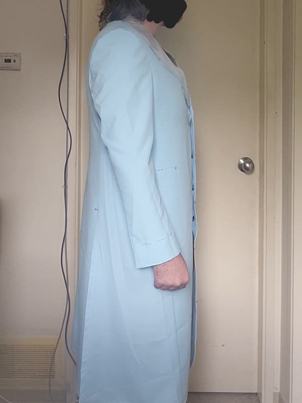 Right side view of a Heath Ledger Joker–inspired purple test coat from The Dark Knight, shown on a male model. This tailoring test garment is used to evaluate overall fit, proportions, and structural alignment before the final coat is made.