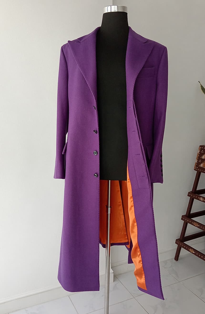 Front view of a Heath Ledger Joker-inspired purple coat from The Dark Knight, displayed on a mannequin. This tailored long coat features a 5-button front closure with a clean placket front and a vivid orange interior lining, reflecting the theatrical styling of the Joker's iconic costume.