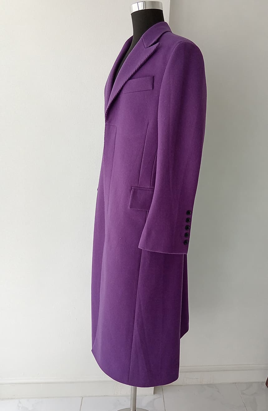 Full side view of a Heath Ledger Joker inspired purple overcoat from The Dark Knight displayed on a mannequin. The coat showcases sharp wide peak lapels, tall welt pocket, 5-button closure, tailored front dart, and dramatic bell sleeve detailing.