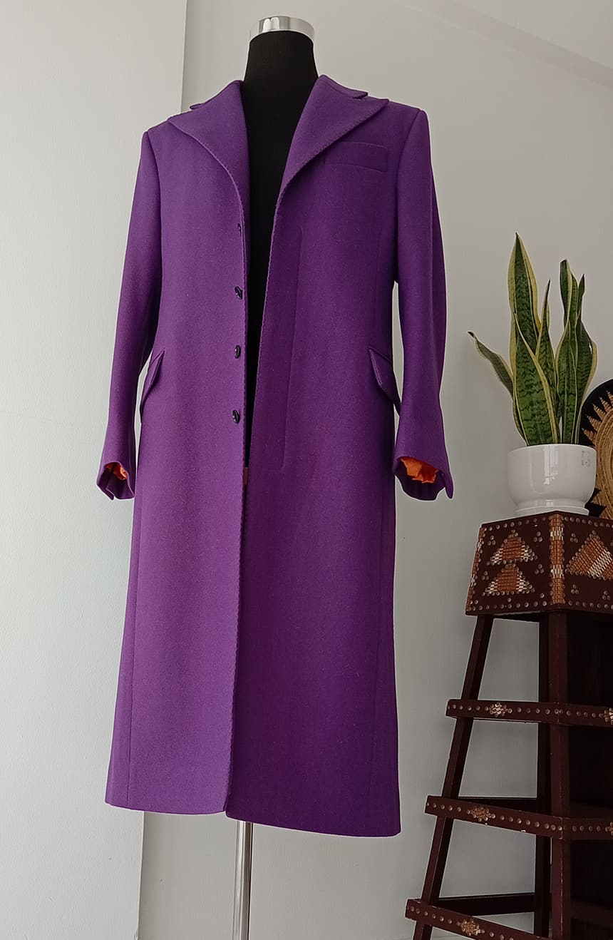 Front view of a Heath Ledger Joker inspired purple coat from The Dark Knight displayed on a mannequin. The tailored long coat features a 5-button front closure, wide peak lapels, fitted silhouette, bell sleeve styling, and dramatic theatrical design inspired by the Joker's iconic costume.