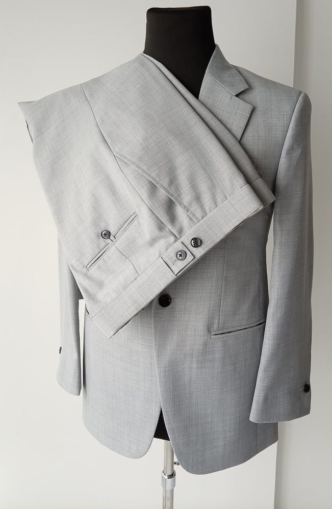 Men's Tom Cruise Collateral suit in light grey worsted wool on mannequin, trouser back pockets with button closure and flat-front construction, detail view