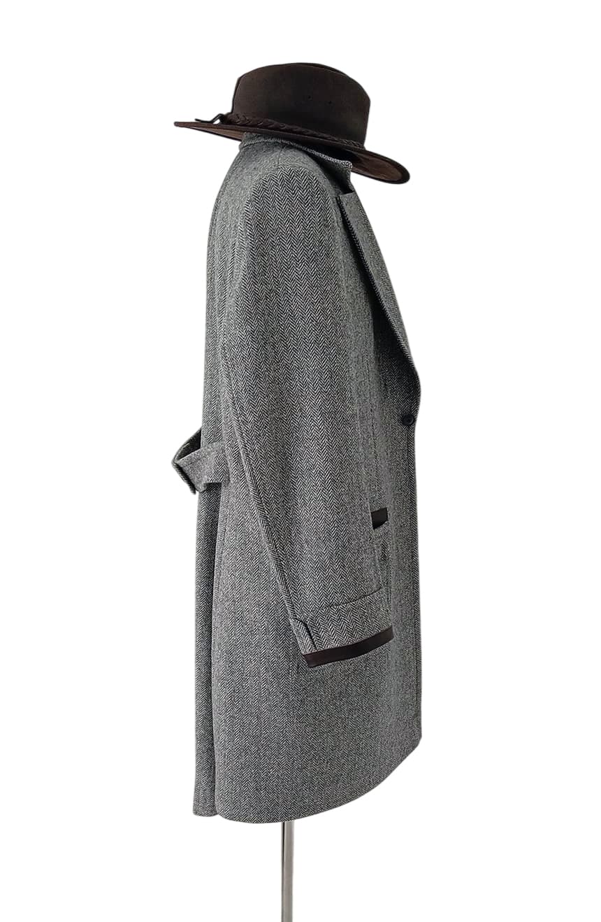 Side profile of British herringbone tweed wizard coat inspired by cinematic fantasy fashion, featuring structured tailoring, leather trim accents, and vintage explorer styling.
