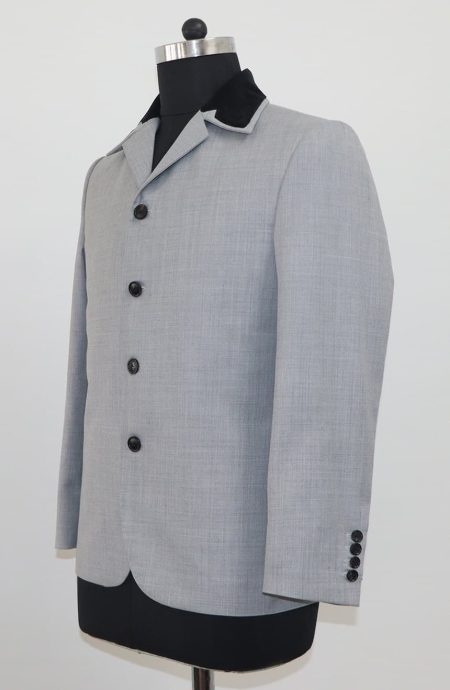 Left side view of a 1960s mod grey suit jacket, showing the structured silhouette and sleeve buttons.