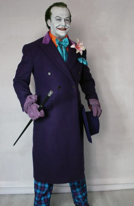 Studio standing view of the 1989 purple coat replica styled with a dynamic walking cane pose, showcasing the structured double-breasted button alignment and deep violet color tone.