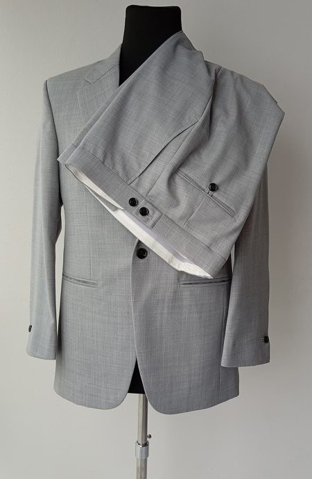 Collateral suit in light grey worsted wool on mannequin, trouser waistband with side-tab adjusters and back pockets visible, detail view