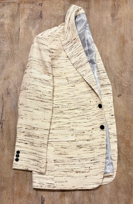 Men's raw silk blazer in unprocessed natural raw silk, side view, peak lapel open showing paisley lining, two-button stance