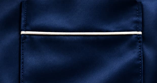 Navy silk chest pocket with an ivory piped top edge on a bespoke pajama shirt.
